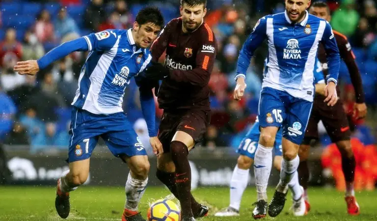 Striker Espanyol Gerard Moreno (kiri) mendapat pengawalan dari bek Barcelona Gerard Pique pada laga La Liga, 4 Februari 2018. (AFP/Pau Barrena)