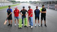 Sejumlah pembalap MotoGP termasuk Francesco Bagnaia (tengah kanan) berfoto bersama setelah bermain kriket di dalam lintasan menjelang MotoGP India 2023 di Sirkuit Buddh, New Delhi, India pada 21 September 2023. (AFP/Money Sharma)