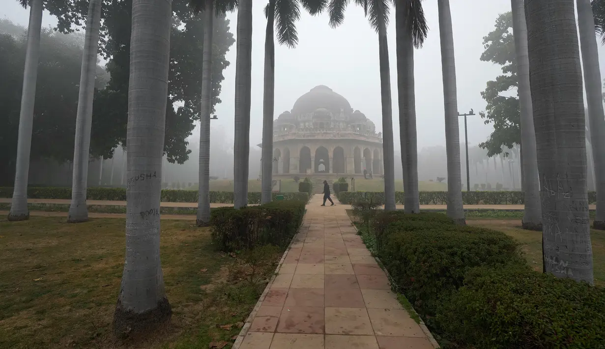 Seorang warga berjalan pada pagi hari di tengah kabut asap, New Delhi, India, Selasa (20/12/2022). India Utara mengalami kabut pertama musim ini dan diperkirakan akan berlangsung selama lima hari ke depan yang mengganggu transportasi kereta api, jalan raya, dan udara. (AP Photo/Manish Swarup)