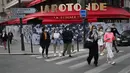 Warga berjalan pulang tepat sebelum jam malam pukul 19.00 di depan restoran Rotonde yang tutup, Paris, Prancis, Kamis (1/4/2021). Prancis bersiap melakukan lockdown setelah pemerintah menemukan adanya lonjakan kasus COVID-19. (AP Photo/Francois Mori)