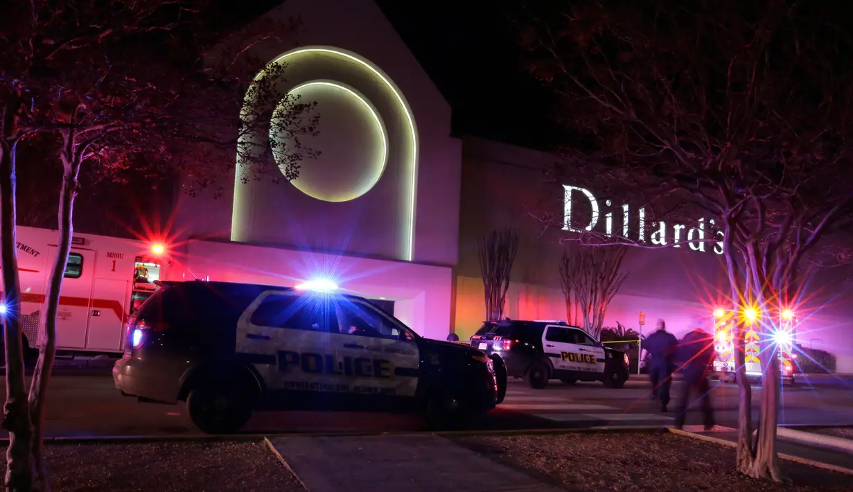 Polisi San Antonio berjaga di pintu keluar setelah terjadinya baku tembak di Rolling Oaks Mall, Texas, Minggu (22/1). Satu orang tewas dan tujuh orang lainnya mengalami luka tembak, termasuk salah satu tersangka. (AP Photo/Eric Gay)