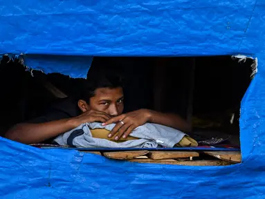 Dalam foto yang diambil pada 19 Juni 2024 ini, seorang pria beristirahat di tempat penampungan pengungsi Rohingya di pantai Kulee, di Kabupaten Pidie, provinsi Aceh. (CHAIDEER MAHYUDDIN/AFP)