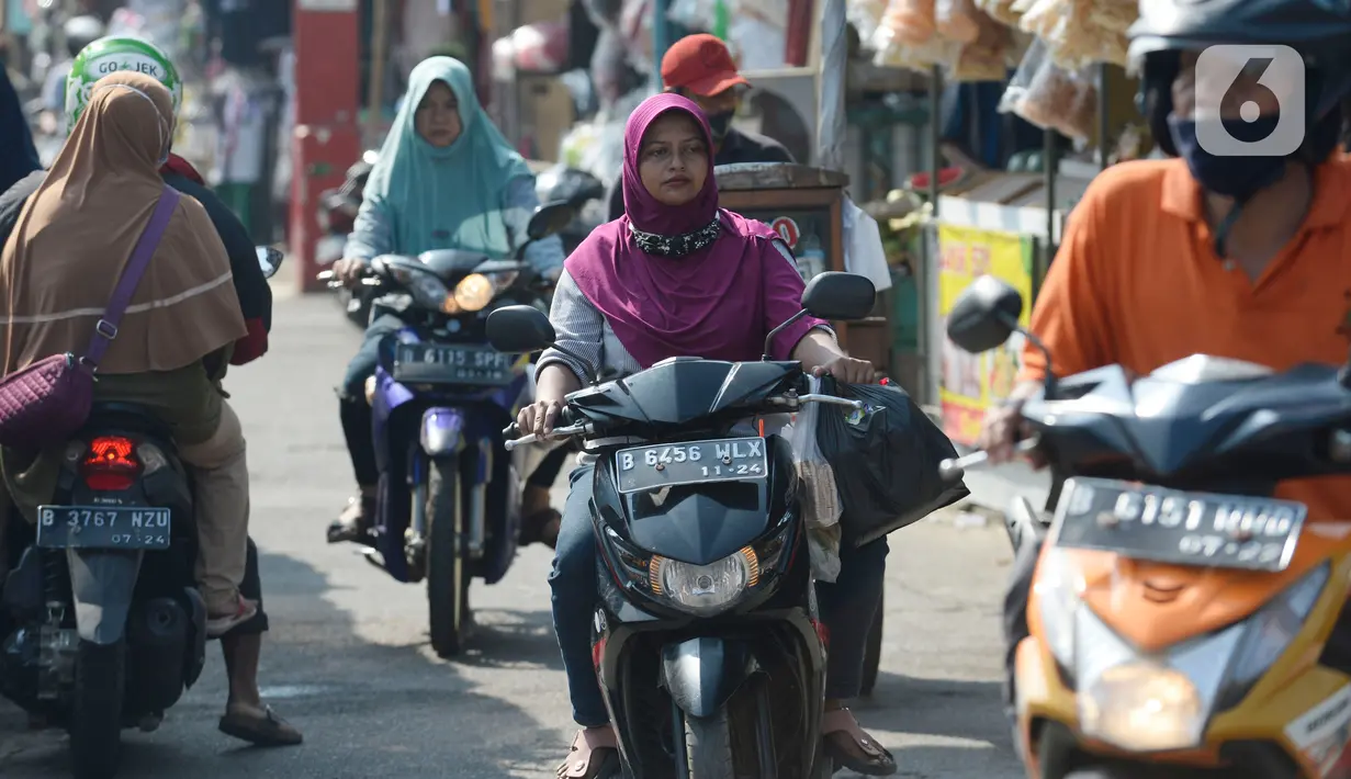 Pengendara motor tidak mengenakan masker masuk ke Pasar Bukit di Tangerang Selatan, Banten, Rabu (22/7/2020). Warga masih tidak peduli kesehatan dirinya sendiri dan orang lain, tentang bahayanya penyeberan virus corona (COVID-19) yang terus meningkat di Indonesia. (merdeka.com/Dwi Narwoko)