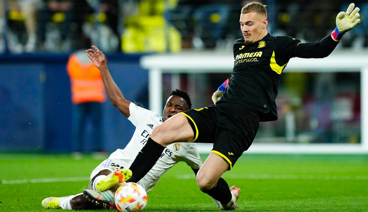 Kiper Villarreal Filip Joergensen melakukan penyelamatan di depan pemain Real Madrid Vinicius Junior pada pertandingan sepak bola babak 16 besar Copa del Rey di Stadion La Ceramica, Villarreal, Spanyol, 19 Januari 2023. Real Madrid mengalahkan Villarreal dengan skor 3-2. (AP Photo/Jose Breton)