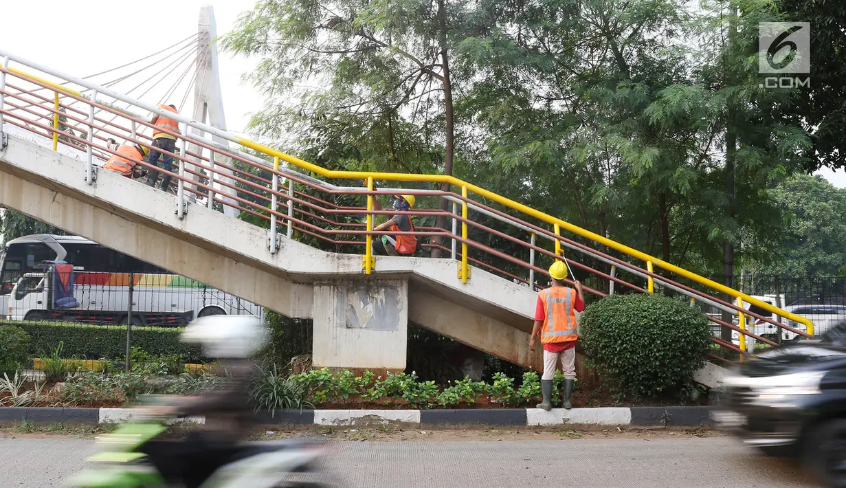 Pekerja mengecat jembatan penyeberangan orang (JPO) di kawasan Cipayung, Jakarta Timur, Rabu (30/5). Pengecatan dilakukan untuk merawat JPO agar tidak kusam dan lebih nyaman digunakan oleh pejalan kaki. (Liputan6.com/Immanuel Antonius)