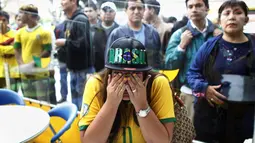 Seorang fans yang menyaksikan laga timnya, menangis setelah gawang Brasil kebobolan pada babak semifinal Piala Dunia 2014 melawan Jerman, Selasa (8/7/14). (REUTERS/Ueslei Marcelino)