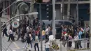 Pegawai keluar dari bangunan setelah gempa melanda Manila, Filipina (11/8). Akibat gempa tersebut istana Malacanang tempat Presiden Rodrigo Duterte berkantor terpaksa dievakuasi. (AP Photo/Aaron Favila)