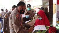 Kapolres Lumajang AKBP AKBP Dewa Putu Eka D (Kanan) menyerahkan 10 kg beras kepada peserta vaksinasi lansia. (Istimewa)
