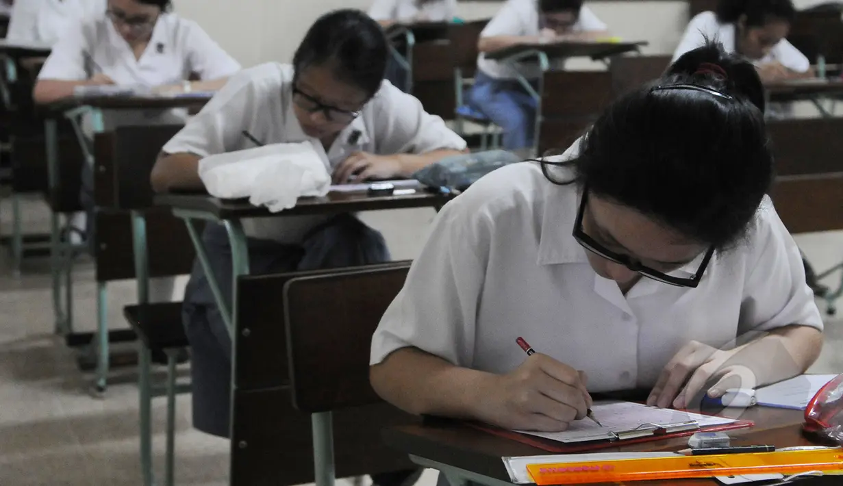 Sejumlah siswi mengikuti Ujian Nasional (UN) secara  Paper Base Test (PBT) di SMA Santa Ursula , Jakarta, Senin (13/4/2015). Mulai hari ini SMA/SMK sederajat menjalani Ujian Nasional 2015 baik secara online maupun Manual. (Liputan6.com/Herman Zakharia)