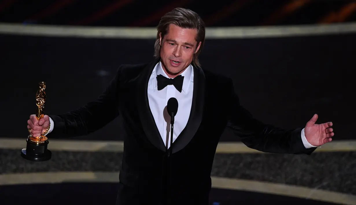 Brad Pitt memberikan pidato saat menerima piala Oscar di atas panggung ajang Academy Awards ke-92 yang digelar di Dolby Theatre, Los Angeles, Minggu (9/2/2020). Brad Pitt menyabet penghargaan sebagai Aktor Pendukung Terbaik untuk aktingnya di film Once Upon a Time in Hollywood. (Mark RALSTON / AFP)