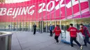 Para pekerja mengantarkan gerobak berisi peralatan ke alun-alun komersial di Desa Olimpiade Musim Dingin, Beijing, China, Jumat, 24 Desember 2021. Olimpiade dan Paralimpiade Musim Dingin 2022 akan diadakan mulai bulan Februari. (AP Photo/Mark Schiefelbein)
