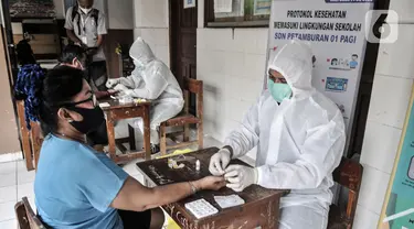 Tim medis dari Polda Metro Jaya saat menggelar rapid test kepada warga di SDN 01 Petamburan, Jakarta, Minggu (22/11/2020). Polda Metro Jaya menggelar rapid test gratis kepada warga Petamburan sebagai langkah mencegah penyebaran Covid-19. (merdeka.com/Iqbal S. Nugroho)