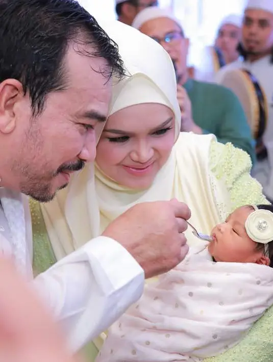 Penyanyi Siti Nurhaliza mendampingi suaminya Datuk Seri Khalid menyuapi anak pertama mereka Siti Aafiyah saat acara akikah. (instagram.com/ctdk)
