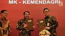 Mendagri Tjahjo Kumolo (kanan) dan Ketua MK Anwar Usman (tengah) menunjukkan dokumen Nota Kesepahaman di Jakarta, Selasa (19/2). Kerja sama ini juga untuk penegakan hukum dan mencegah terjadinya kriminalitas. (Merdeka.com/Iqbal Nugroho)