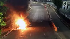 Api menyala membakar salah satu unit kendaraan kawat berduri milik aparat kepolisian di Jalan Gatot Subroto, Jakarta, Rabu (29/9/2019). Massa yang rata-rata berseragam sekolah dan pramuka bentrok dengan petugas sehingga jalan depan Kompleks Parlemen lumpuh. (Liputan6.com/HelmiFithriansyah)