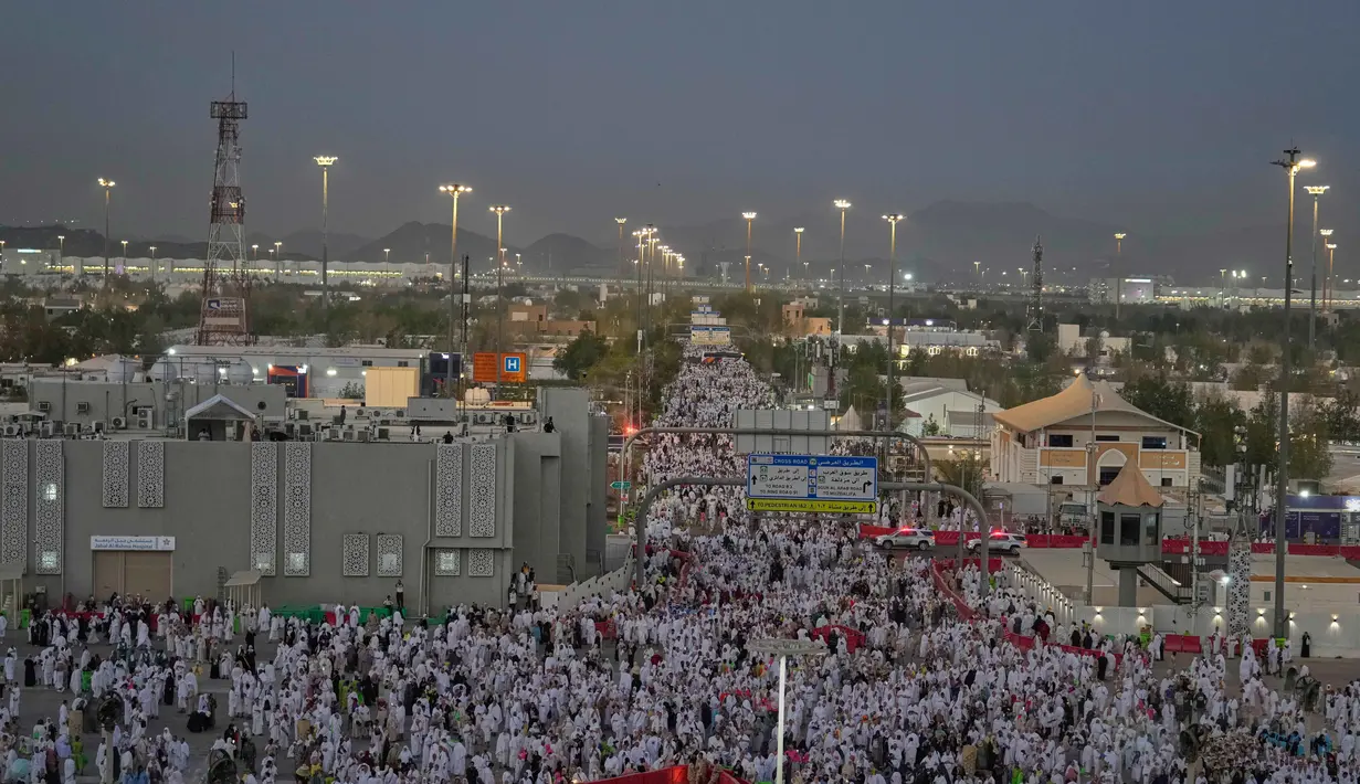 Umat Muslim berjalan menuju bukit berbatu yang dikenal sebagai Jabal Rahmah atau Gunung Rahmat, di Dataran Arafah, selama ibadah haji tahunan di dekat kota suci Mekah, Arab Saudi, Selasa 26 Mei 2026. (AP Photo/Altaf Qadri)