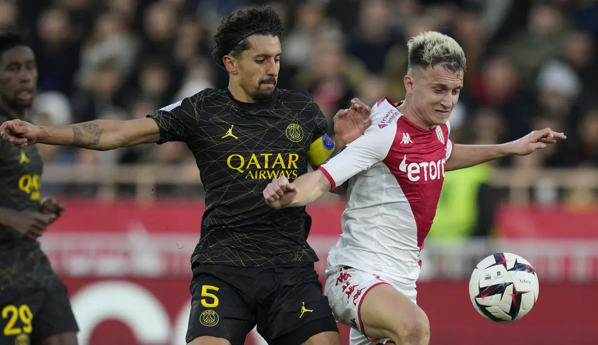 Gelandang AS Monaco Aleksandr Golovin berebut bola dengan bek Paris Saint-Germain (PSG) Marquinhos dalam laga Ligue 1 2022/2023 pekan ke-23 di Stade Louis II, Sabtu (11/2/2023) malam WIB. Sementara itu, tiga gol Monaco tercatat atas nama Aleksandr Golovin (4') dan Wissam Ben Yedder (18', 45+2'). (AP Photo/Daniel Cole)