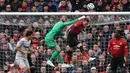 Kiper Man United, David de Gea melakukan penyelamatan pada laga lanjutan Premier League yang berlangsung di Stadion Old Trafford, Minggu (14/4). Man United menang 2-1 atas West Ham. (AFP/Paul Ellis)