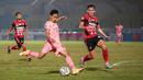 Pemain Madura United, Haris Tuharea (tengah) melepaskan tendangan dibayangi pemain Bali United, Komang Tri Arta dalam laga pekan ke-16 BRI Liga 1 2021/2022 di Stadion Sultan Agung, Bantul, Kamis (09/12/2021). (Bola.com/Bagaskara Lazuardi)