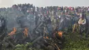 Polisi dan pekerja kehutanan bersama penduduk desa menyaksikan tubuh gajah dibakar setelah kereta penumpang melaju menabrak dua gajah yang melintasi rel di desa Batasi dekat perbatasan India-Nepal, sekitar 37 km dari Siliguri (11/12/2019). (AFP/Diptendu Dutta)