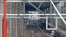 Pekerja menyelesaikan pembangunan proyek Stasiun Sudirman Baru di Jakarta, Minggu (23/7). Pyoyek tersebut merupakan salah satu dari 5 stasiun yang dibangun khusus untuk menunjang Kereta Bandara Soetta. (Liputan6.com/Immanuel Antonius)