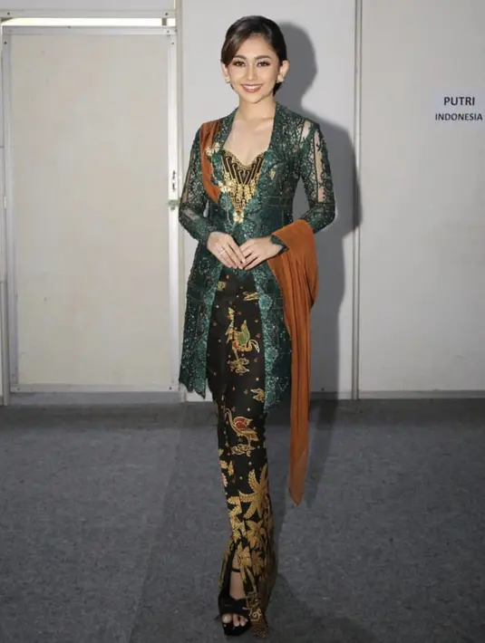 Putri Indonesia Favorite Kepulauan Sulawesi 2022, Dini Nurfitri Widjaja bergaya elegan dengan kebaya hijau dipadukan kain batik. Instagram/diniwdjaya