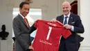 Presiden Joko Widodo (kiri) memberikan jarsey kepada Presiden Induk Asosiasi Sepakbola Dunia (FIFA) Gianni Infantino saat bertemu di Istana Negara, Jakarta, Selasa (18/10/2022). Pertemuan ini khusus antara FIFA dengan pemerintah Indonesia. (AP Photo/Achmad Ibrahim)