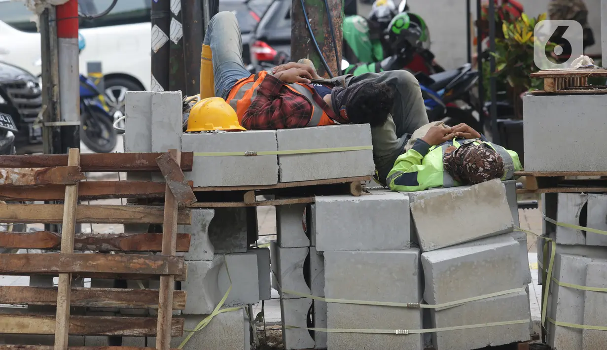 Pekerja beristirahat di sela proyek revitalisasi trotoar di kawasan Senopati, Kebayoran Baru, Jakarta, Rabu (15/9/2021). Pada tahun 2021, trotoar yang akan dibangun kurang lebih 41 ribu meter persegi di 5 wilayah. (Liputan6.com/Herman Zakharia)
