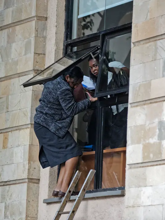 Warga melarikan diri melalui jendela saat terjadi penyerangan kelompok bersenjata ke sebuah kompleks hotel mewah di Nairobi, Kenya, Selasa (15/1). Sejumlah orang dibawa ke rumah sakit karena terluka. (AP Photo/Ben Curtis)