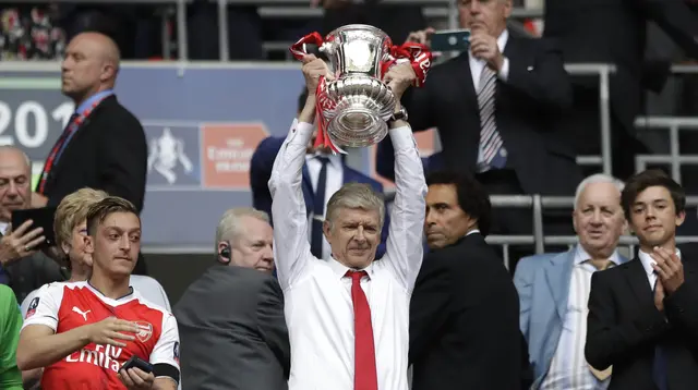 Pelatih Arsenal, Arsene Wenger, mengangkat trofi usai menjuarai final Piala FA melawan Chelsea di Stadion Wembley, Sabtu (27/5/2017). Arsenal menang 2-1. (AP/Matt Dunham)