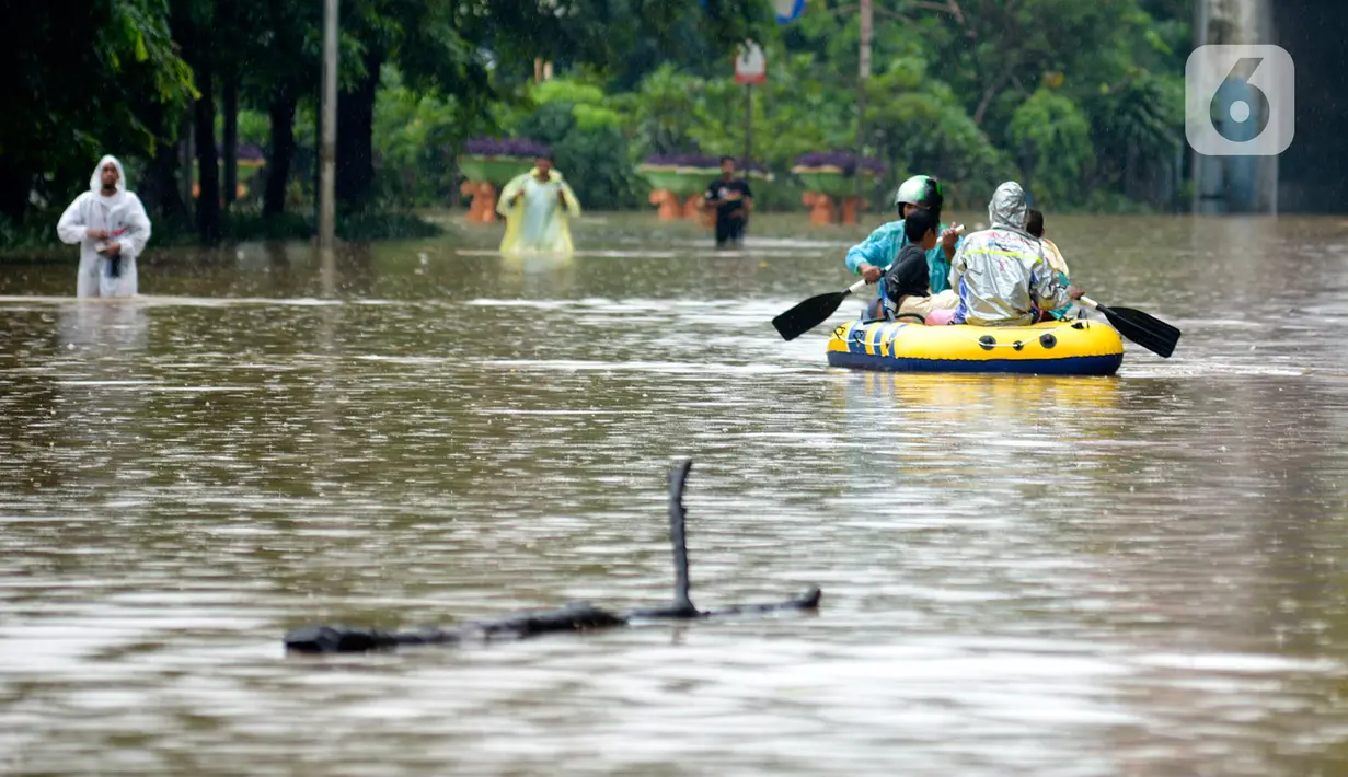 Warga menaiki perahu karet saat melewati kawasan Cawang-Uki, Jalan DI Panjaitan, Jakarta, Selasa (25/2/2020). Hujan yang mengguyur Jakarta sejak dini hari tadi membuat kawasan tersebut terendam banjir sekitar satu meter. (merdeka.com/Imam Buhori)
