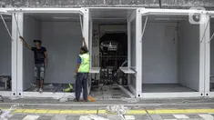 Para pekerja memasang kios untuk pedagang kaki lima (PKL) di atas trotoar usai direvitalisasi di kawasan Tugu Proklamasi, Menteng, Jakarta Pusat, Jumat (30/12/2022). Sebanyak 92 kios bongkar pasang dengan luas masing-masing 2x2 meter ini diperuntukkan bagi pedagang makanan agar lebih tertata rapi. (Liputan6.com/Faizal Fanani)