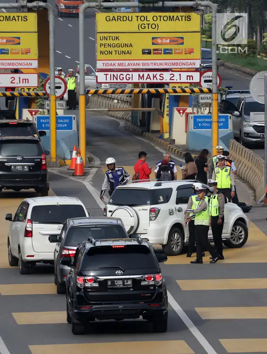 Petugas mengarahkan kendaraan berplat genap berputar balik di Gerbang Tol Bekasi Barat 1, Bekasi, Jawa Barat, Selasa (13/3). Hari kedua penerapan ganjil genap, masih banyak kendaraan berputar balik di gerbang tol tersebut. (Liputan6.com/Arya Manggala)