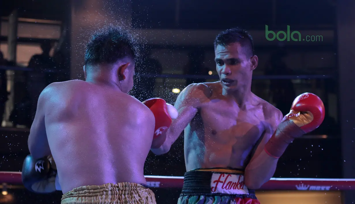 Ilham Leoisa (kanan) memukul di wajah petinju Thailand, Paiboon Lorkham pada kelas Super-Lightweight Mahkota Boxing Super Series di Cilandak Town Square, Jakarta (10/3/2018). Ilham menang angka mutlak. (Bola.com/Nick Hanoatubun)