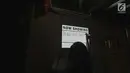 Seorang petugas Bioskop Tunantra menulis di papan pengumuman jelang pemutaran film di Bioskop Bisik di Pavilliun 28, Jakarta, Minggu (14/1). Hal ini membuat menonton bioskop bukan menjadi hal mustahil lagi bagi tunanetra. (Liputan6.com/Faizal Fanani)