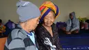 Dua orang wanita lansia berbincang usai dievakuasi di tempat penampungan sementara di Kabupaten Klungkung, Bali (22/9). Para penduduk desa dievakuasi sehubungan meningkatnya aktivitas Gunung Agung. (AFP Photo/Sonny Tumbelaka)