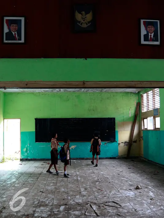 Sejumlah siswa SDN 12 Kramat Jati, Jakarta, tampak melihat ruang kelas mereka yang kondisinya sangat memprihatinkan, Rabu (21/10). Sejak mulai direhab dua tahun lalu, sampai saat ini renovasi belum juga selesai.  (Liputan6.com/Yoppy Renato)