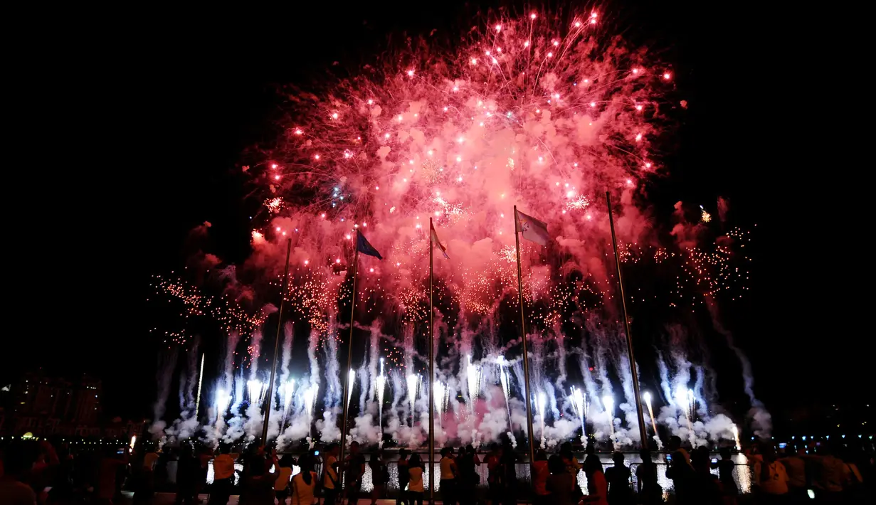 Pesta kembang api melatarbelakangi bendera negara peserta saat pembukaan Sea Games 2015 di National Stadium Singapura, Jumat (5/6/2015). Sea Games 2015 berlangsung pada 5-16 Juni dan melombakan 36 cabang olahraga. (Liputan6.com/Helmi Fithriansyah)
