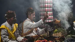 Para pemimpin komunitas melakukan ritual sebelum mendaki gunung berapi aktif Bromo untuk mempersembahkan sesaji berupa beras, buah-buahan, ternak, dan barang-barang lainnya sebagai bagian dari festival Yadnya Kasada di dekat Probolinggo, Jawa Timur, Senin 1 Juni 2026. (JUNI KRISWANTO/AFP)