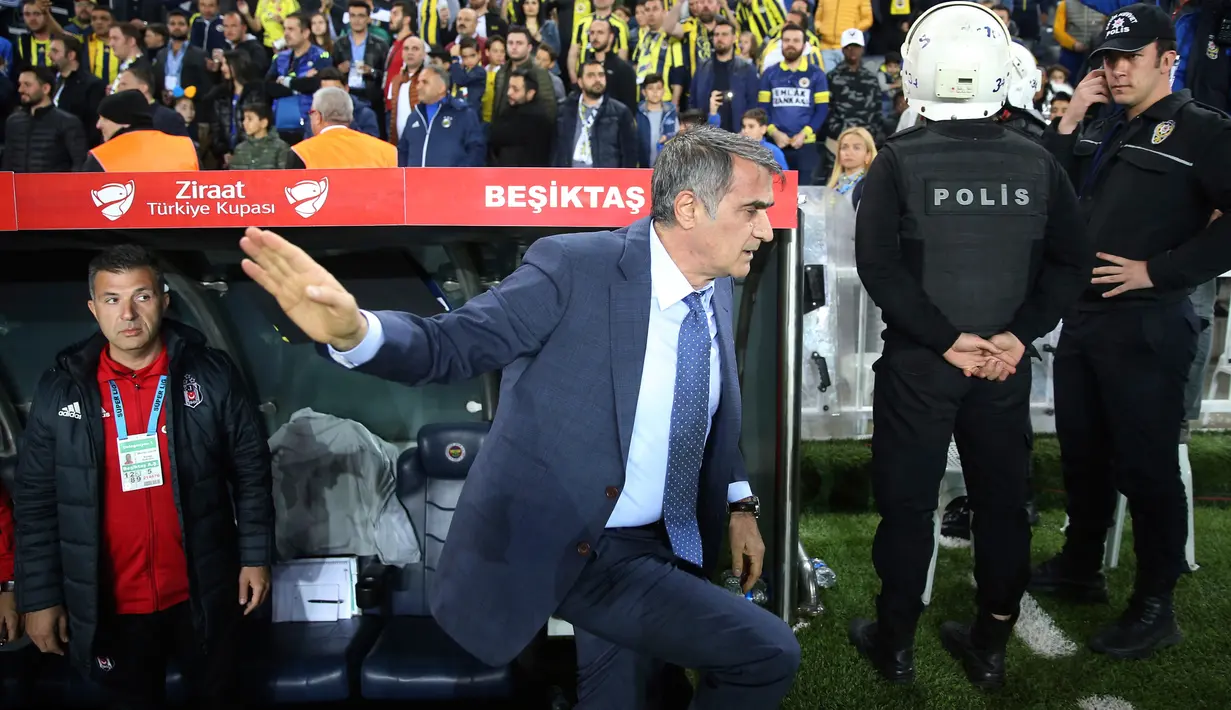 Pelatih Besiktas, Senol Gunes setelah kepalanya terkena lemparan benda tajam dari tribun penonton pada semifinal Piala Turki melawan Fenerbahce di Istanbul, Kamis (19/4). Pertandingan memanas usai pemain Besiktas, Pepe diganjar kartu merah. (AP)