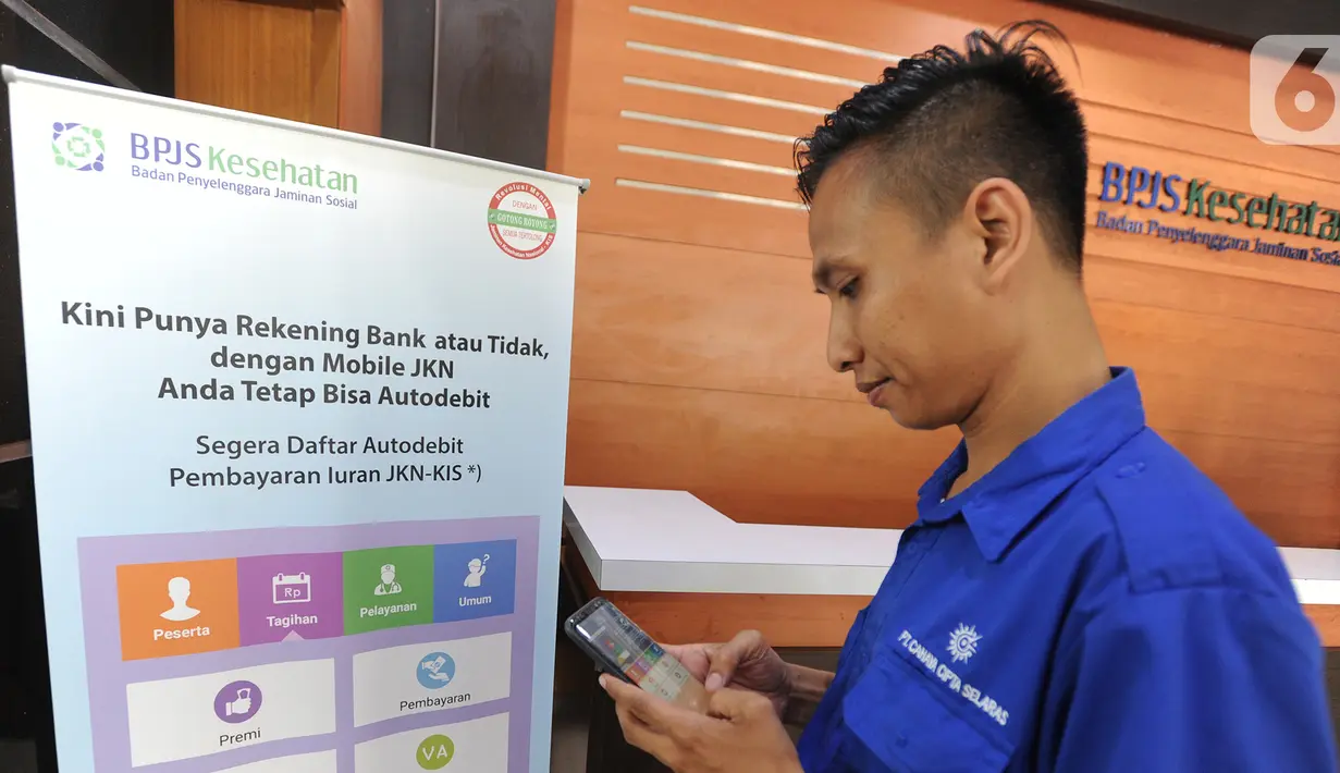Warga menggunakan handphonenya saat mengurus iuran BPJS Kesehatan di Kantor BPJS Jalan Raya Pasar Minggu, Jakarta, Senin (4/11/2019). Perhimpunan Rumah Sakit Seluruh Indonesia memprediksi akan terjadi migrasi turun kelas peserta akibat kenaikan iuran 100 persen. (merdeka.com/Arie Basuki)