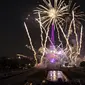 Kembang api menerangi Menara Eiffel selama perayaan Hari Bastille di Paris, Kamis (14/7/2022) malam. Penyerbuan penjara Bastille dipandang sebagai simbol pemberontakan bangsa dan rekonsiliasi seluruh rakyat Prancis. (AP Photo/Lewis Joly)
