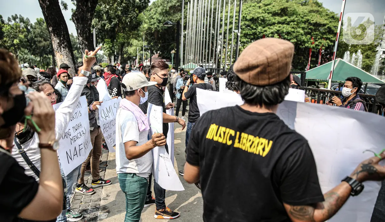 Sejumlah musisi kafe saat melaksanakan aksi di depan Balai Kota Jakarta, Rabu (8/7/2020). Aksi ngamen di depan Balai Kota Jakarta yang diikuti oleh musisi kafe itu untuk menyuarakan aspirasi pekerja seni harian yang terdampak mata pencahariannya selama masa PSBB. (Liputan6.com/Faizal Fanani)