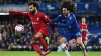 Striker Liverpool, Mohamed Salah dibayangi bek Chelsea, Marc Cucurella di Stamford Bridge, Rabu (5/4/2023) dini hari WIB. (AFP/Glyn Kirk)