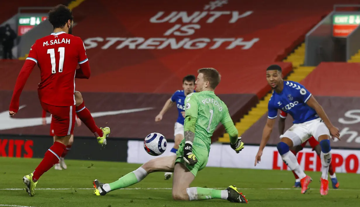 Pemain Liverpool Mohamed Salah melepaskan tendangan ke gawang Everton yang dijaga kiper Jordan Pickford pada pertandingan Liga Inggris di Anfield, Liverpool, Inggris, Sabtu (20/2/2021). Liverpool kalah 0-2. (Phil Noble/Pool via AP)