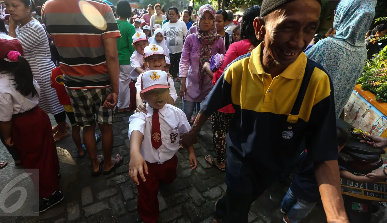 Orangtua mengantarkan anaknya masuk kelas usai upacara pada hari pertama sekolah di SDN Pasar Baru 05 Jakarta, Senin (18/7). Usai libur Idul Fitri, para siswa kembali mengikuti pelajaran di sekolah untuk tahun ajaran 2015-2016 (Liputan6.com/Faizal Fanani)