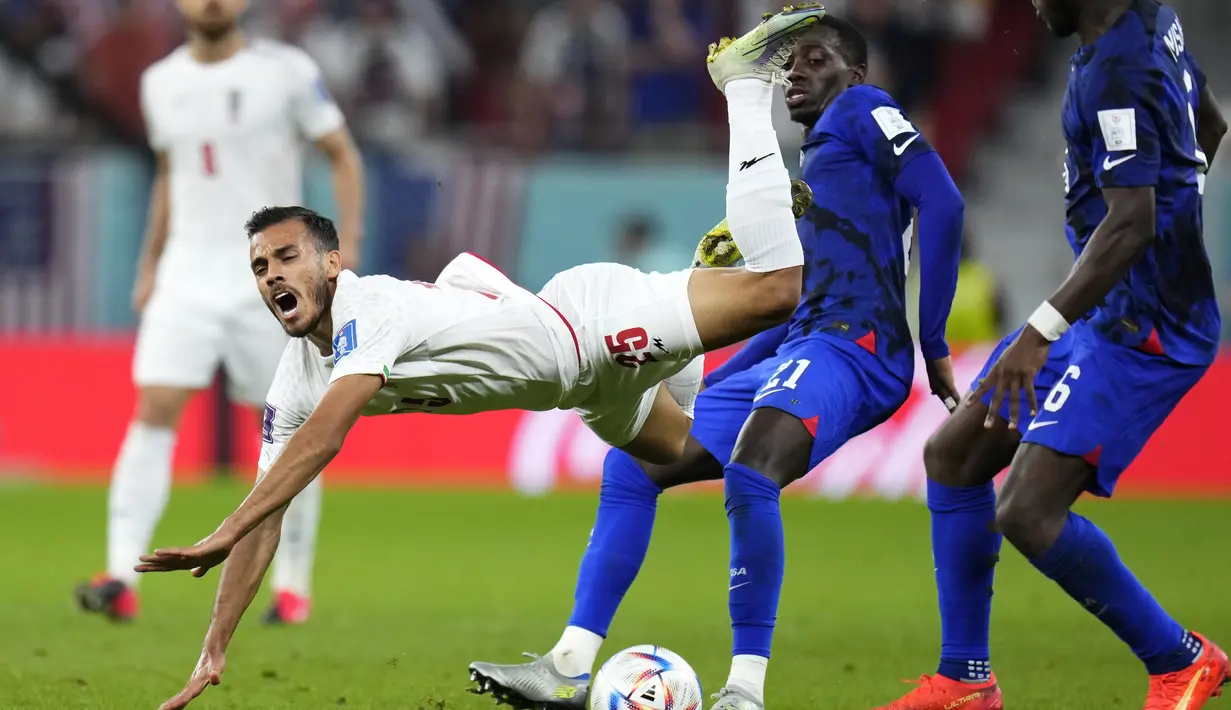 Penyerang Amerika Serikat Tim Weah menantang bek Iran Abolfazi Jalali pada laga pamungkas Grup B Piala Dunia 2022 di Stadion Al Thumama, Rabu (30/11/2022) dini hari WIB. Dengan hasil ini, Amerika Serikat lolos ke babak 16 besar Piala Dunia 2022 menghadapi juara Grup A, Belanda pada Sabtu (3/12/2022). (AP Photo/Manu Fernandez)