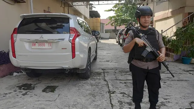 Polisi mengawal penyidik KPK menggeledah rumah pengusaha hiburan malam terkait proyek jalan di Bengkalis.