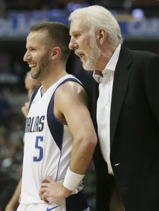 Pelatih San Antonio Spurs, Gregg Popovich (kanan) berbincang dengan pemain Dallas Mavericks, J.J. Barea (5) pada laga NBA Basketball game di American Airlines Center, Dallas, (14/11/2017). Spurs menang 97-91. (AP/LM Otero)