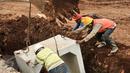 Pekerja memasang beton saluran air di proyek normalisasi Ciliwung, Bukit Duri, Jakarta, Rabu (8/2). Penyelesaian normalisasi Ciliwung mencakup pembangunan dinding parapet, sheetpile, jalan inspeksi maupun saluran air.(Liputan6.com/Yoppy Renato)